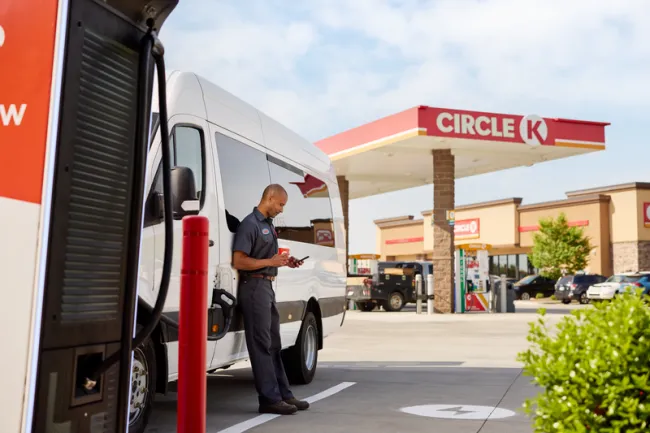 man using his phone by a charging station