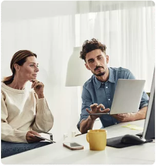 person explaining something on laptop screen to another person
