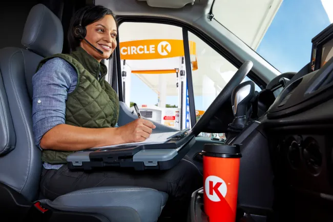 woman on a call using her headset in a van outside Circle K