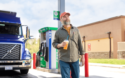 Man walking towards a Circle K station store after parking his truck to fuel