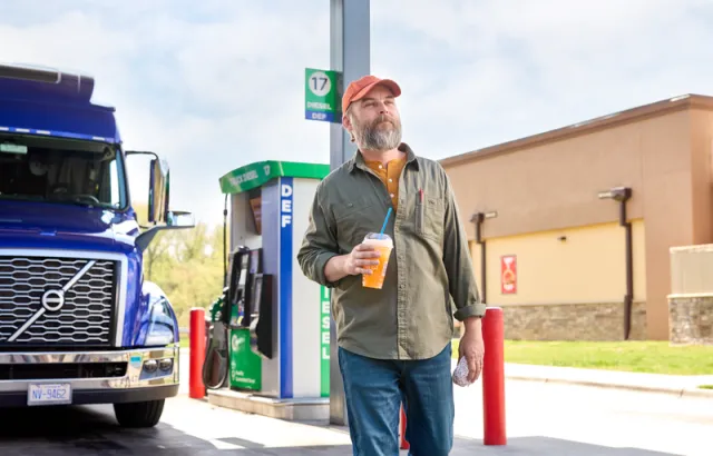 Truck Driver Walking With Drink in Hand