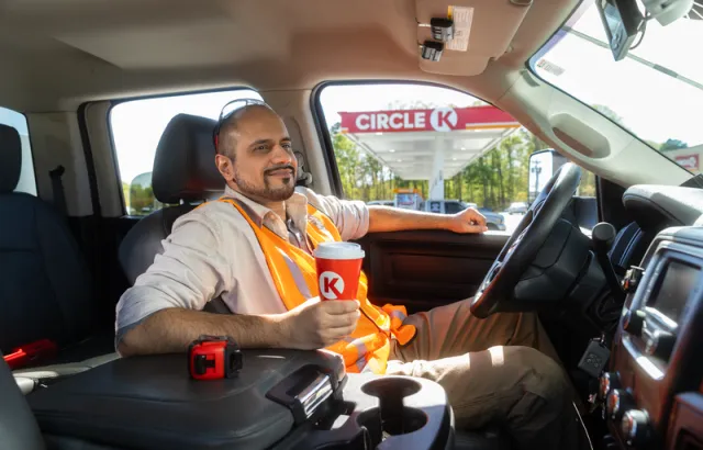 Business driver sitting in his vehicle outside Circle K with a coffee in hand