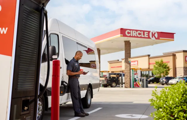 Man looking at his Circle K Pro card administration on his phone, outside a Circle K station