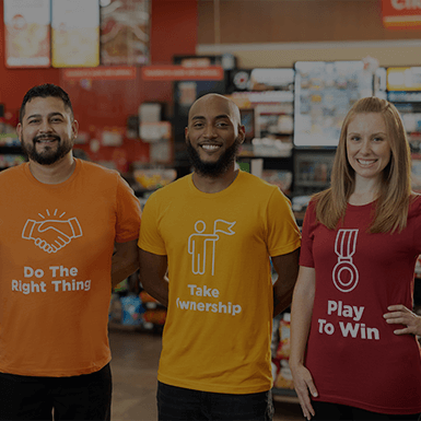 Three Circle K employees wearing t-shirts with the company's values: Do the right thing, take ownership, and play to win.