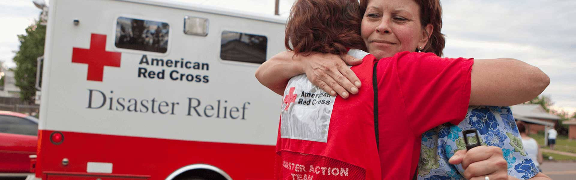 An American Red Cross Disaster Relief worker embraces a woman.