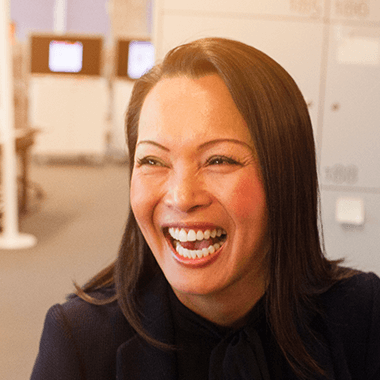 Woman laughing in an office room.