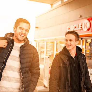Two men smiling at a Circle K storefront.