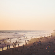 A crowd of people enjoying the sunset at a beach.